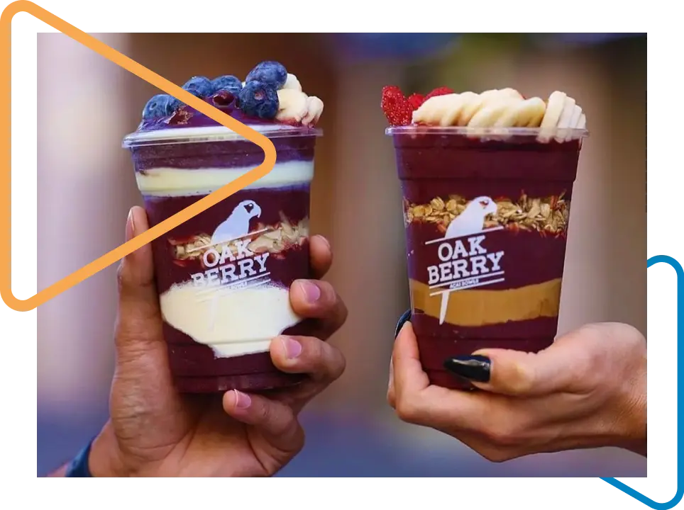 Two people holding Oakberry açaí bowls.