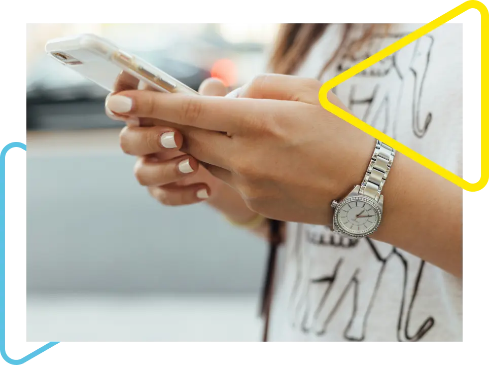 Mulher segurando o celular em pé, representando a união do ambiente físico e digiral da Onebrain